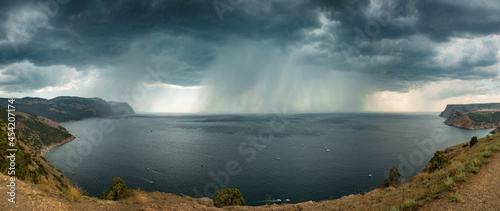 Heavy rain over the sea, bad weather, atmospheric phenomena. Panorama, view from the mountain