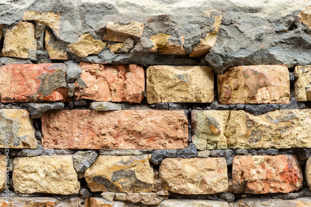 Broken decay old plaster of brick stone wall texture. Damaged erosion bumpy gloomy facade. Broken decay old plaster of brick stone wall texture. Damaged erosion bumpy gloomy facade.