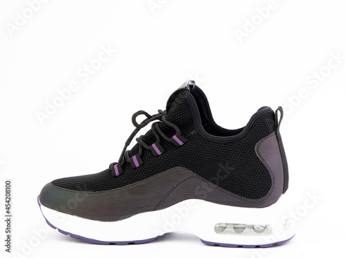 Women's black and purple hiking boots isolated white background. Left side view. Fashion shoes. Photoshoot for shoe shop concept.