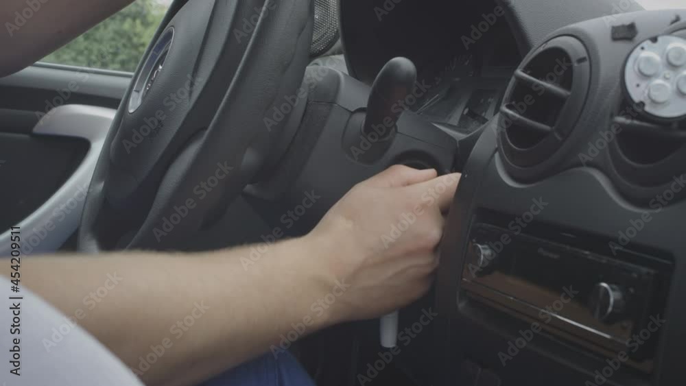 Starting car engine. The man starts a mechanical car. Turns the ignition key, starts the car. Inserts the key into the ignition.