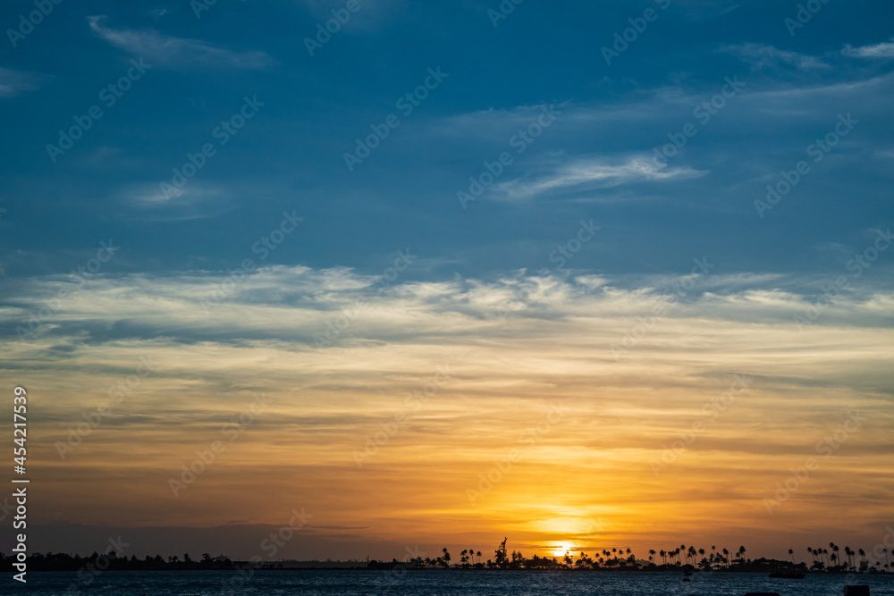 Sunset near the coast line with palm trees in the horizon Sunset near the coast line with palm trees in the horizon