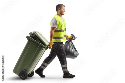 Bin man walking and pulling a green bin and carrying a plastic bag photo