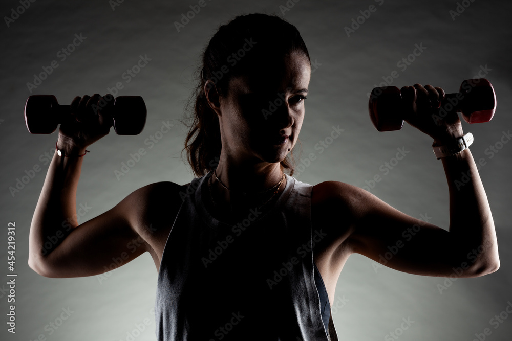 Fitness girl posing and lifting weights. Positive smiling expression. Fitness girl posing and lifting weights. Positive smiling expression.