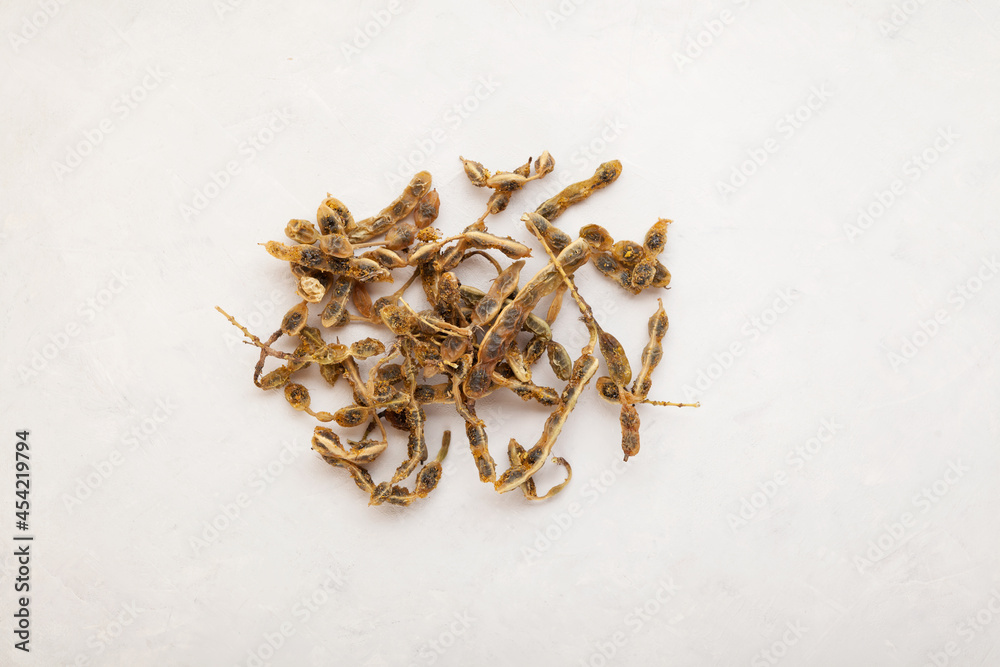 Dried fruits of Sophora japonica on light background, top view. Fruits and seeds are used in alternative medicine, contain rutin, fatty oils, linoleic acid Dried fruits of Sophora japonica on light background, top view. Fruits and seeds are used in alternative medicine, contain rutin, fatty oils, linoleic acid