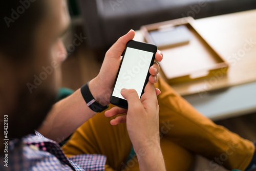 Rear view of a man checking his phone