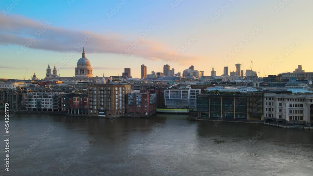 buildings on Thames river waterfront. St. Paul's Cathedral with dominant dome lit from side by morning sun buildings on Thames river waterfront. St. Paul's Cathedral with dominant dome lit from side by morning sun