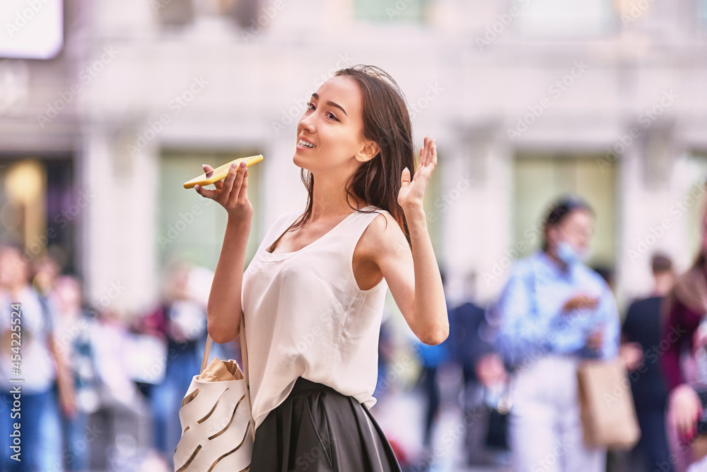 Slender woman is talking by phone on crowded street. Slender woman is talking by phone on crowded street.