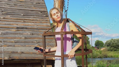Young beautiful girl in hanging cage for torturing people, middle ages and inquisition, punishment methods, vintage torture devices and sex toys photo