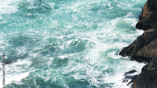 Tableau sur toile Waves break on rocky shore (texture)