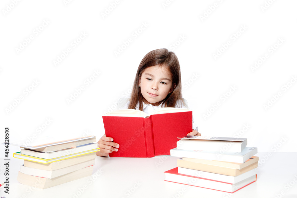 Young cute girl sitting at the table and reading a book Young cute girl sitting at the table and reading a book