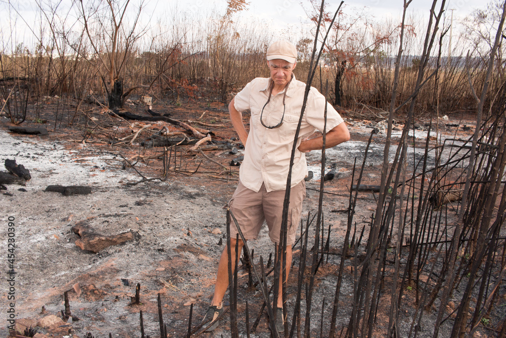 Man from the environment inspecting the remains of a brush fire at an illegal trash dump in Granja do Torto, north of Brasilia, Brazil Man from the environment inspecting the remains of a brush fire at an illegal trash dump in Granja do Torto, north of Brasilia, Brazil