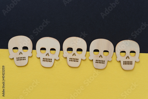 row of retro halloween wooden shapes (skulls) on black and yellow construction paper