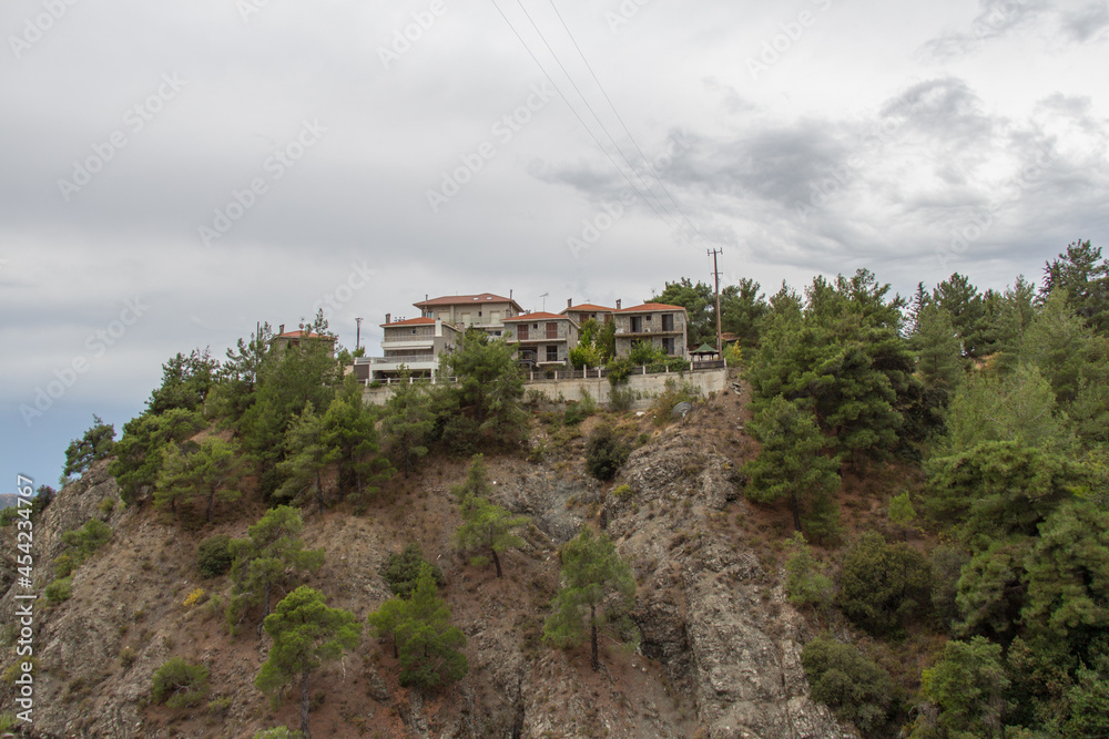 The houses on the rock over the nature trail along the Kryos river valley to the Millomeris waterfall. Platres, Cyprus.