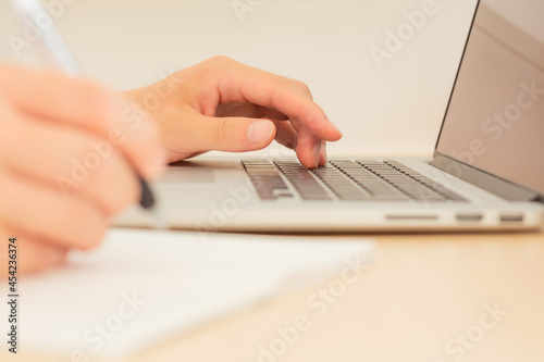 hand of freelancer working remotely on a laptop computer in tokyo, japan