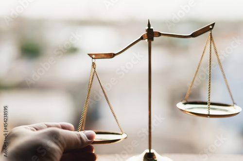 Tableau sur toile Tip the scales of justice concept as a the hand of a person illegally influencing the legal system for an unfair advantage