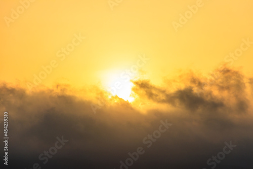 Beautiful rising orange sun above the clouds in sky at sunrise