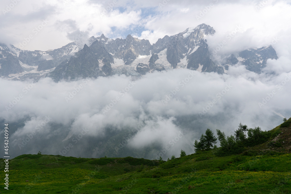 Landscape view of Alps. Peaks cover by clouds and fog because of stormy weather