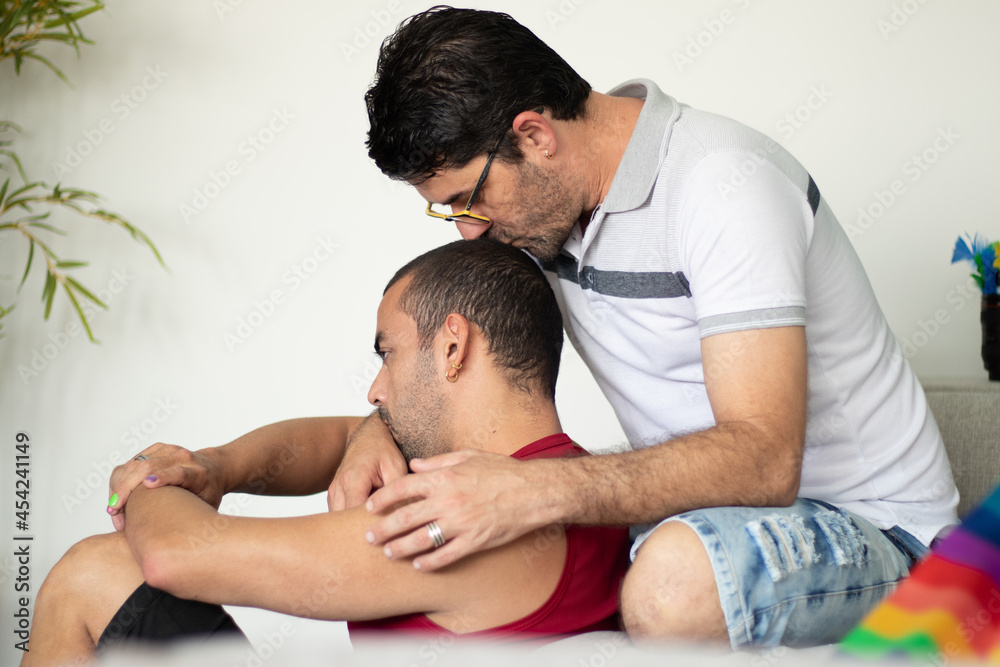 beautiful gay couple sitting on the couch making out. beautiful gay couple sitting on the couch making out.