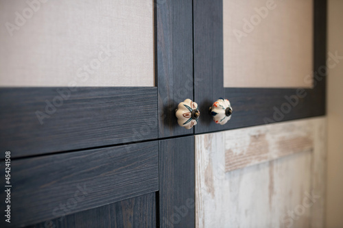Decorative handles on doors of stylish cabinet