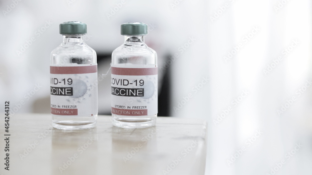 Two bottles of vaccine are placed on a doctor's desk in a hospital lab. Two bottles of vaccine are placed on a doctor's desk in a hospital lab.