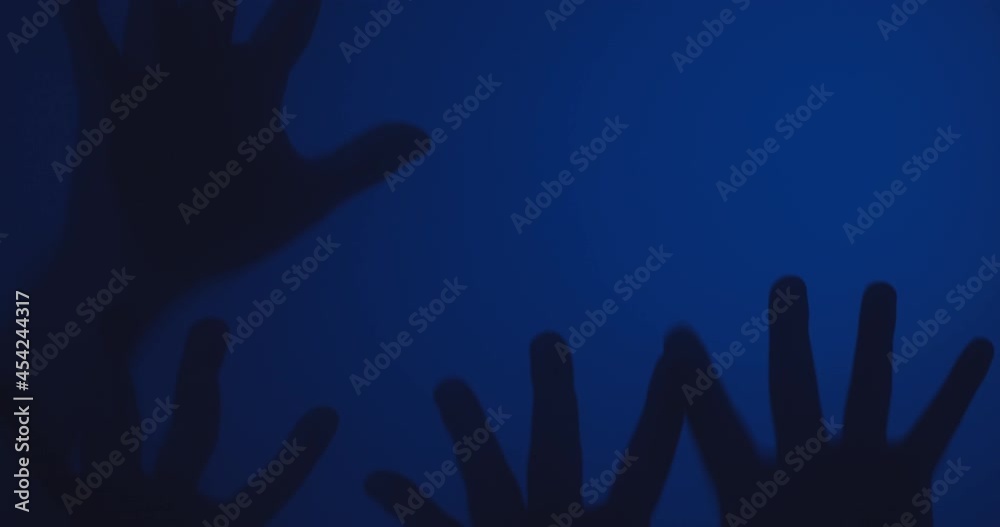 Silhouette of Creepy human hands moving on glass window Silhouette of Creepy human hands moving on glass window