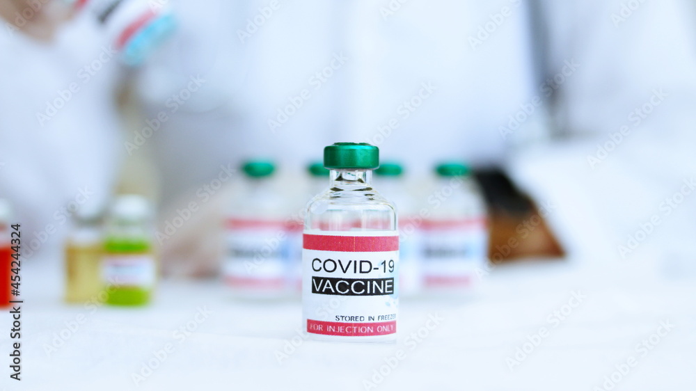Coronavirus or COVID-19, 2019 - nCoV vaccine in a bottle with syringe,vaccine vial with physician supplies in background Coronavirus or COVID-19, 2019 - nCoV vaccine in a bottle with syringe,vaccine vial with physician supplies in background