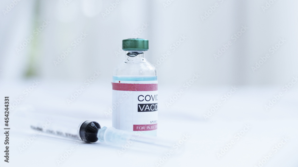 Coronavirus or COVID-19, 2019 - nCoV vaccine in a bottle with syringe,vaccine vial with physician supplies in background Coronavirus or COVID-19, 2019 - nCoV vaccine in a bottle with syringe,vaccine vial with physician supplies in background
