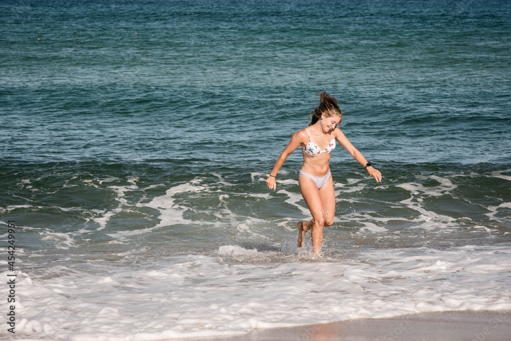gorgeous young woman in bikini by the ocean