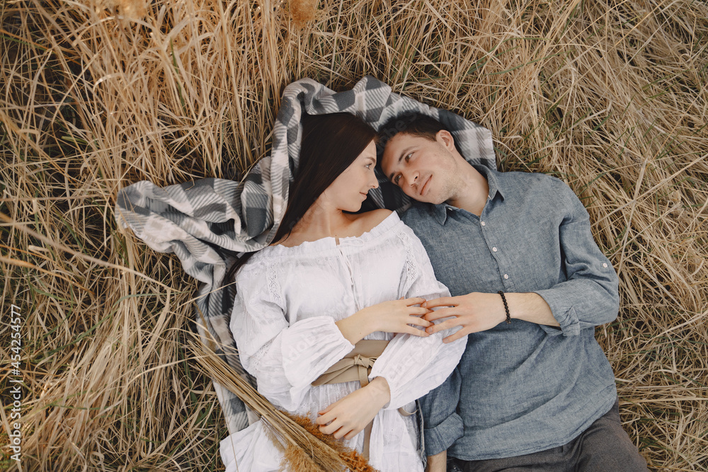 Obraz premium Happy couple in love in wheat field at sunset