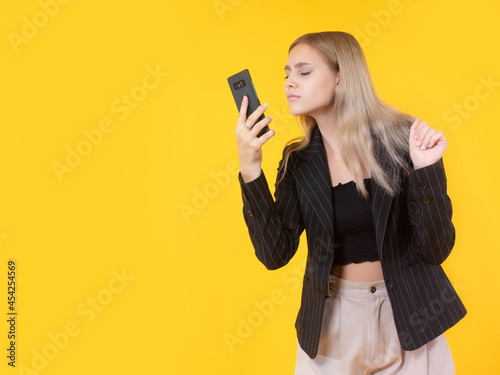 Girl looks at phone. Blonde...