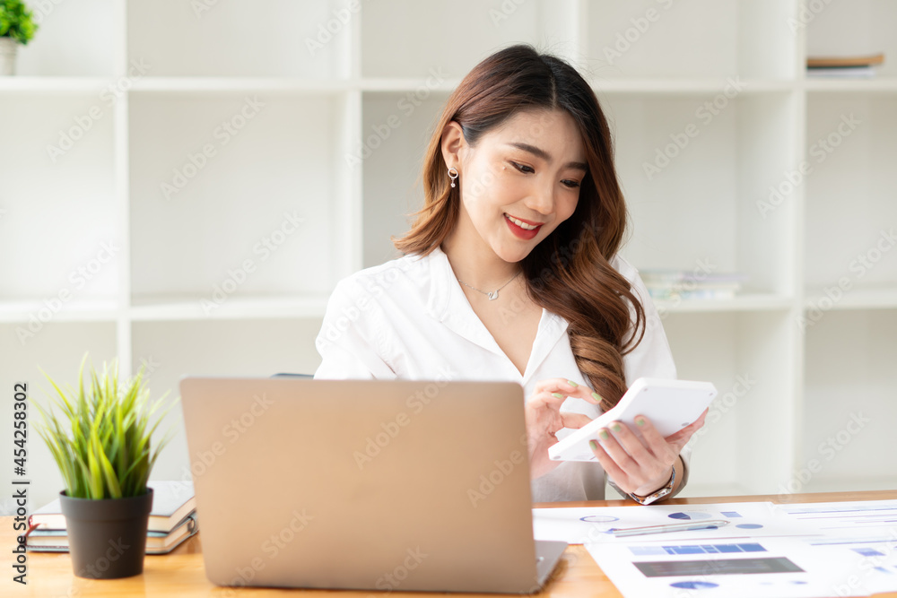 Young asian business woman working on computer laptop in office room with paperwork document on desk Young asian business woman working on computer laptop in office room with paperwork document on desk