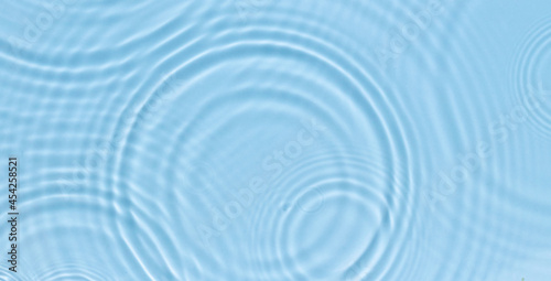 Water panoramic banner background. White aqua texture, surface of ripples, rings, transparen and sunlight. Spa concept background. Flat lay, top view, copy space