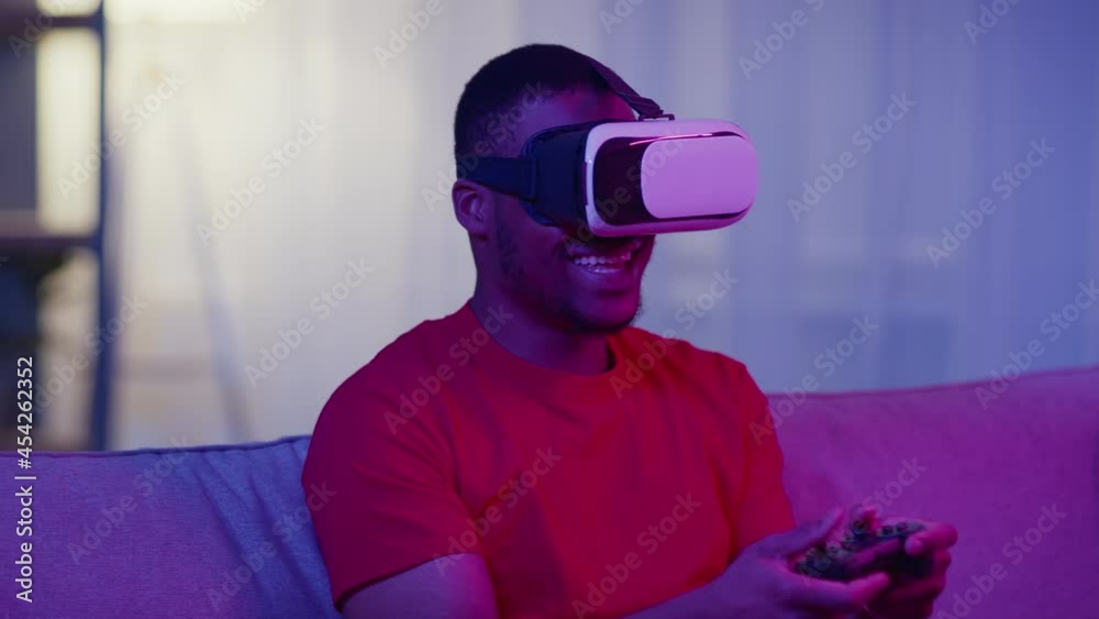 African Guy Wearing VR Headset Playing Computer Game At Home African Guy Wearing VR Headset Playing Computer Game At Home