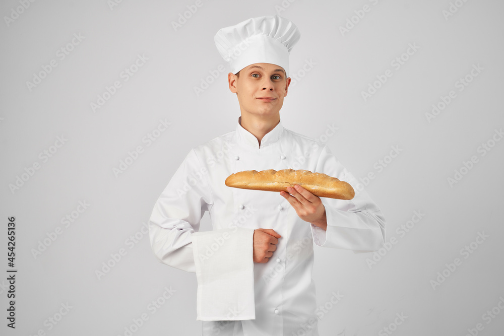 male chef with a baguette in his hands fresh product professional work male chef with a baguette in his hands fresh product professional work