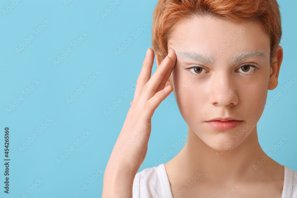 Teenage boy with dyed eyebrows on color background Teenage boy with dyed eyebrows on color background
