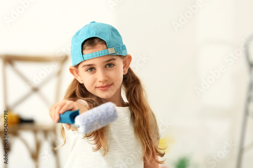 Little girl with paint roll...