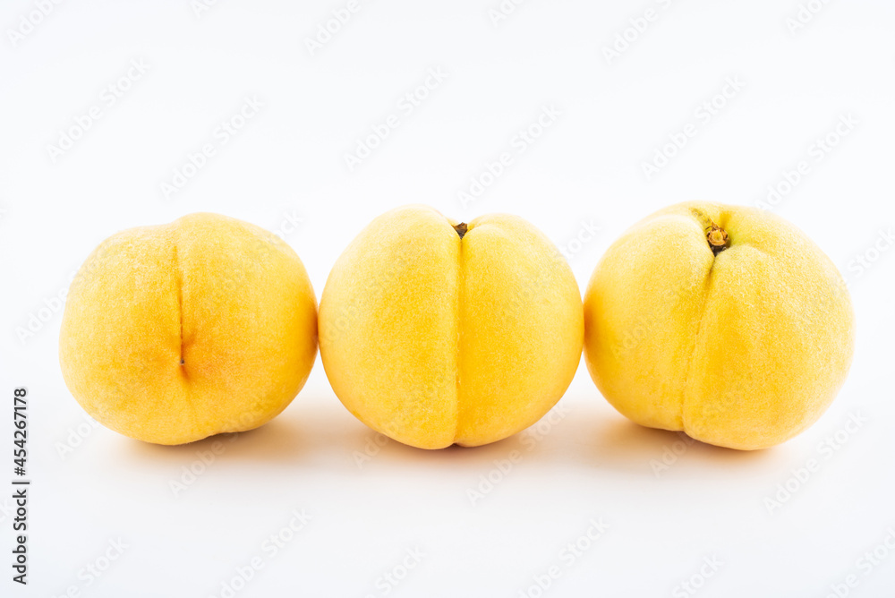 Fresh yellow peaches on white background