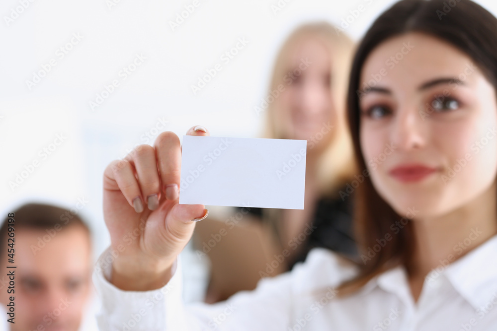 Female hand in suit give blank calling card to visitor