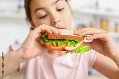 Little girl eating tasty sa...