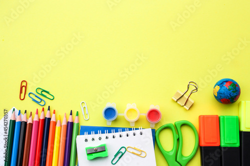 School objects on a yellow background. View from above