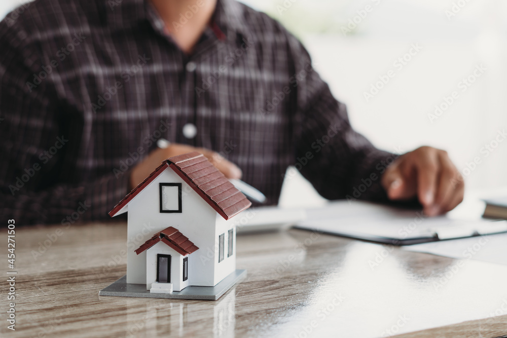 Property investment concept, image of small house model on the table. and home loan insurance. Property investment concept, image of small house model on the table. and home loan insurance.