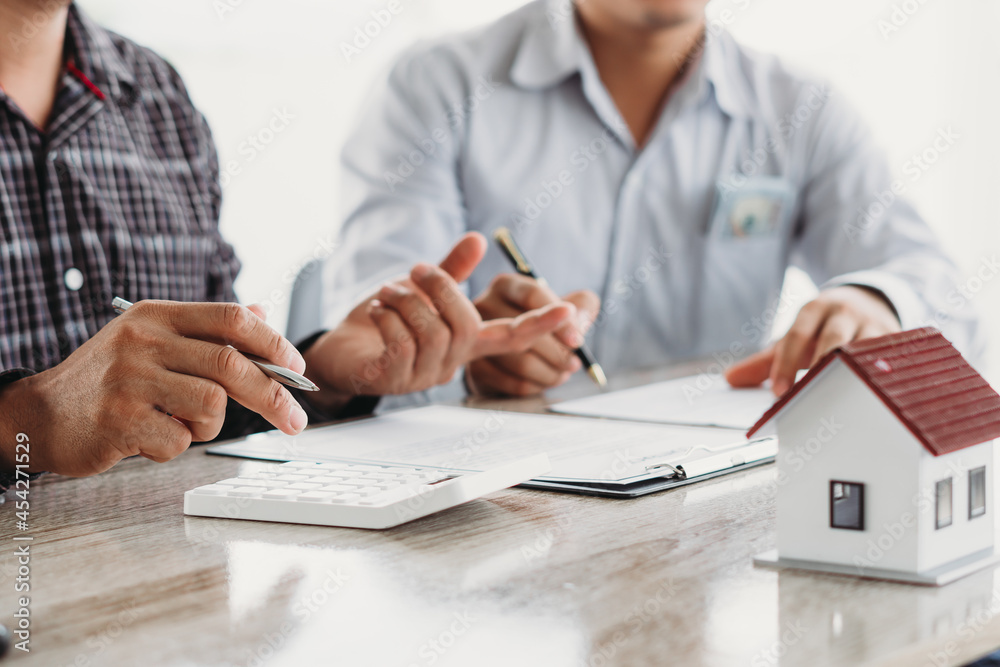 Fototapeta premium Real estate broker agent presenting and consult to customer to decision making sign insurance form agreement, buy and sell home model, concerning mortgage loan offer for and house insurance