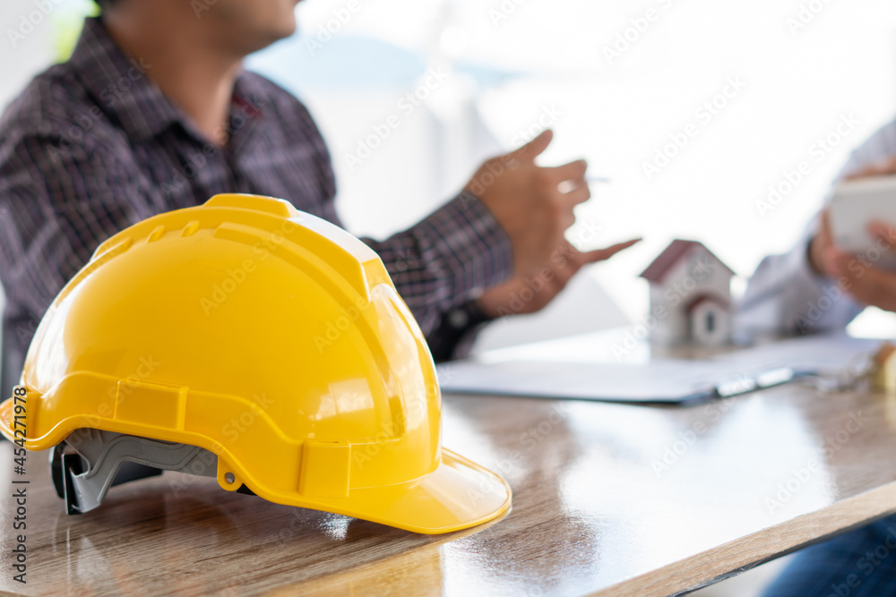 Team engineer meeting for colleagues discussing and checks construction blueprints on new project at desk in office. Team engineer meeting for colleagues discussing and checks construction blueprints on new project at desk in office.