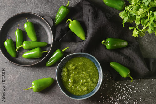 Φωτογραφία Bowl of Tomatillo Salsa Verde sauce and jalapeno pepper on dark background