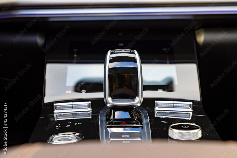 the chrome-plated part of car interior close up. gear knob and multimedia bottoms. gear lever of an automatic transmission in a modern car