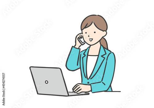 ノートパソコンを操作しながら通話をするビジネスウーマン