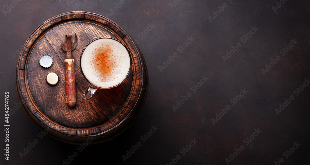 Lager beer mug and bottle opener on old wooden barrel Lager beer mug and bottle opener on old wooden barrel