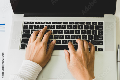 Close up of female hands while typing on laptop
