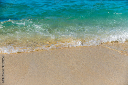 morka fala rozpływająca siena złocistej piaszczystej plaży 