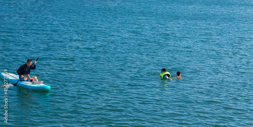 夏の海でサップボードを遊んでいる親子の姿
